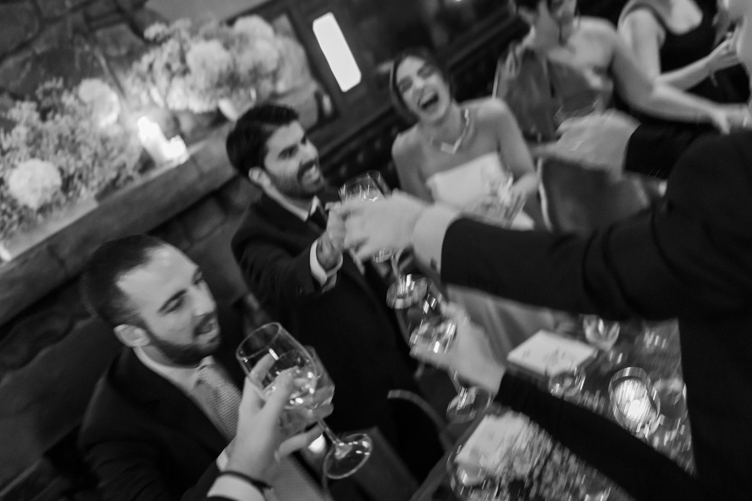 wedding guests exchanging cheers at long table