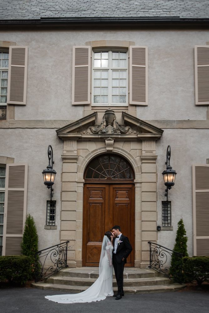 bride and groom kiss in front of french chateau