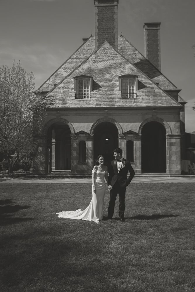 black and white photo of bride and groom in front of a chateau