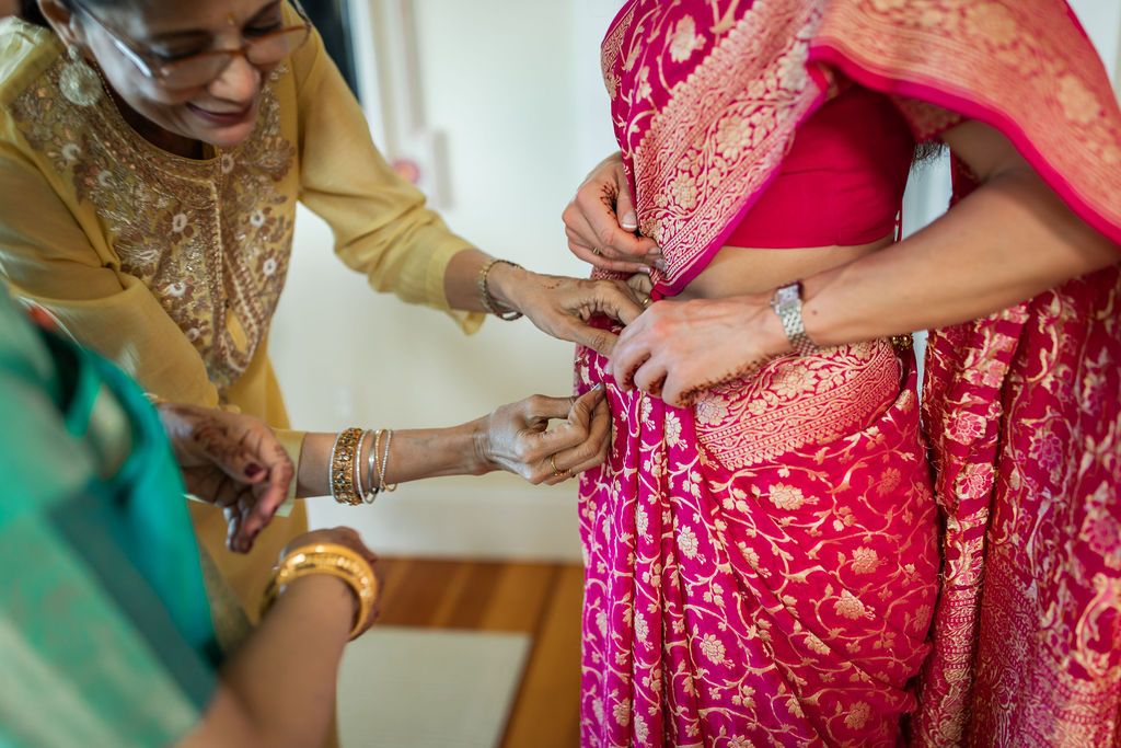 woman adjusting pink garments for indian wedding ceremony