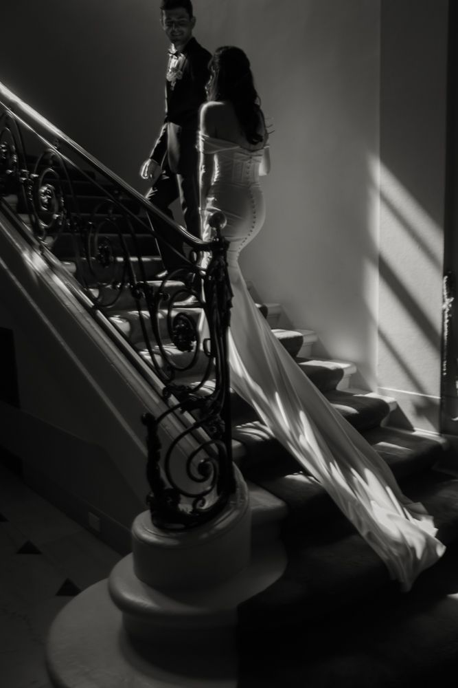 black and white photo of bride and groom going up the stairs