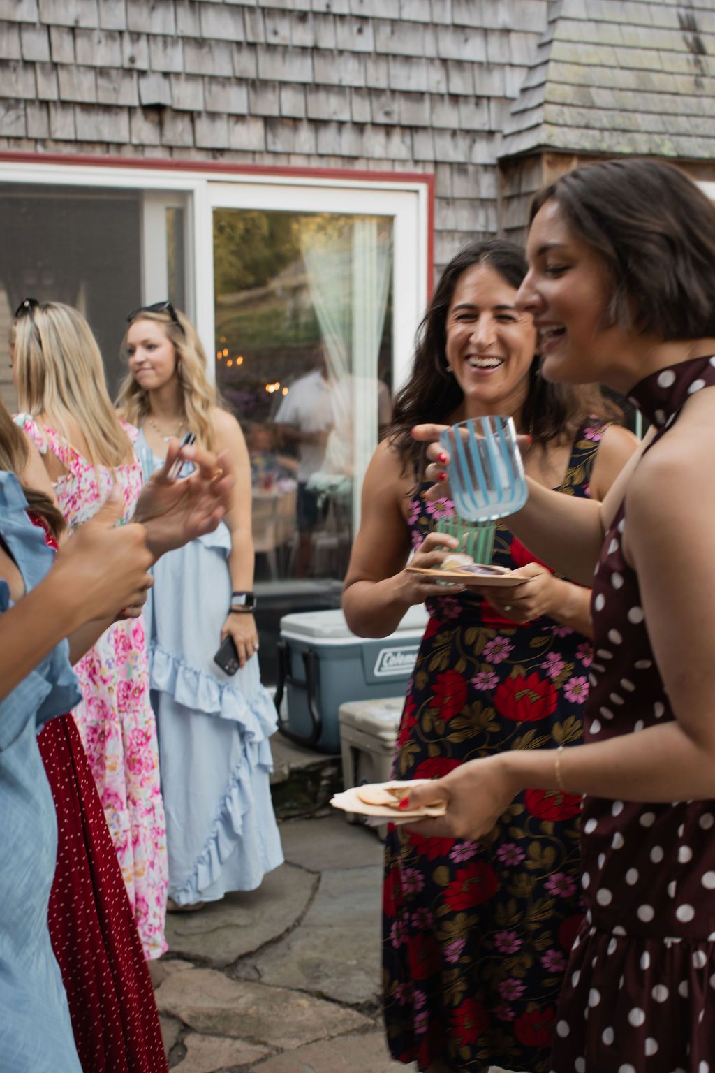guests gather and chat over cocktails at backyard wedding