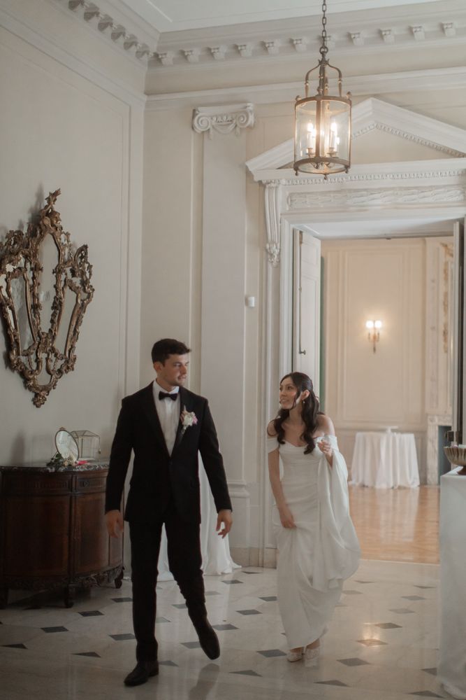 bride and groom walking inside mansion