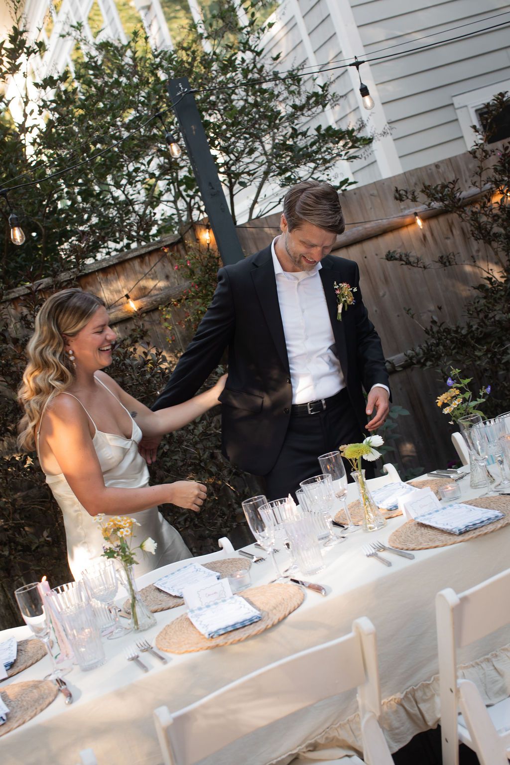 bride and groom laugh together at backyard wedding