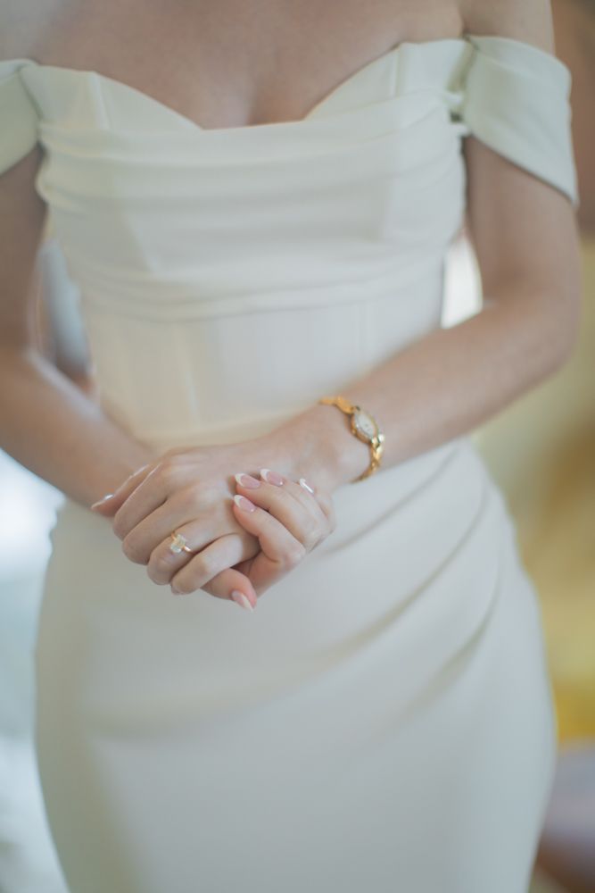 bride holding her own hands in wedding gown