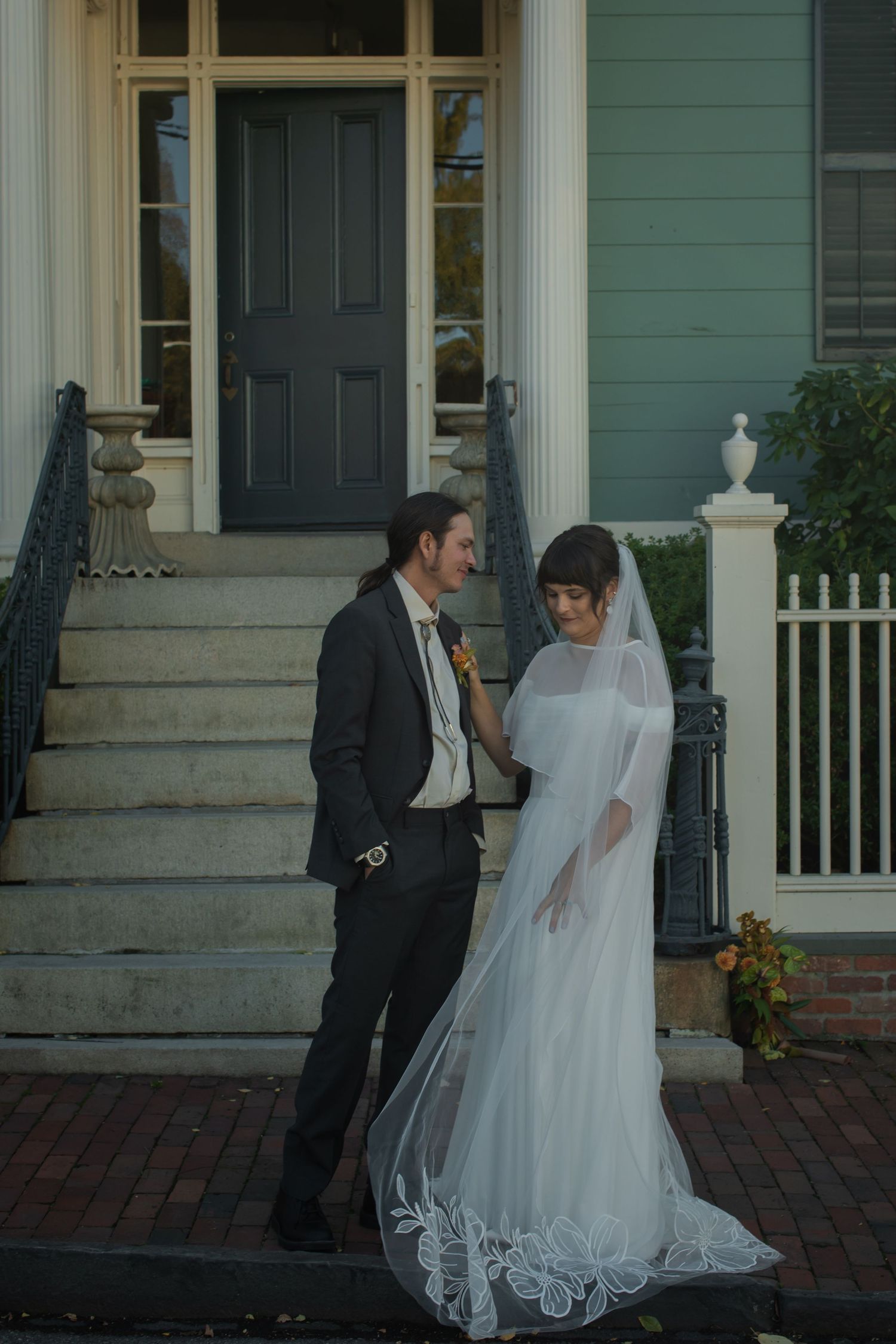 A wedding couple shares an intimate moment on the steps of a historic house in Newport, rhode island
