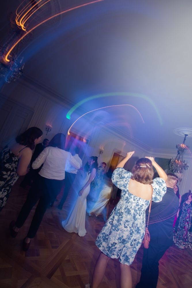 guests dancing under colorful lights at wedding reception