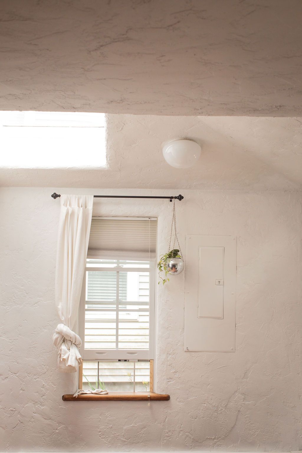 white window frame against textured walls with natural light streaming in.