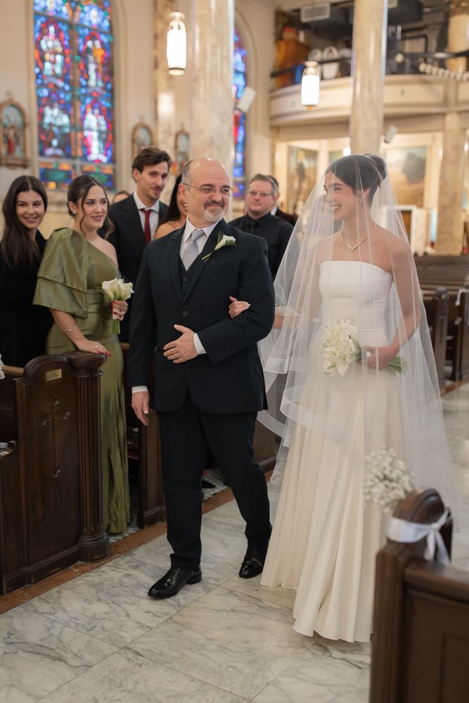 color photo of bride and father walking down the aisle