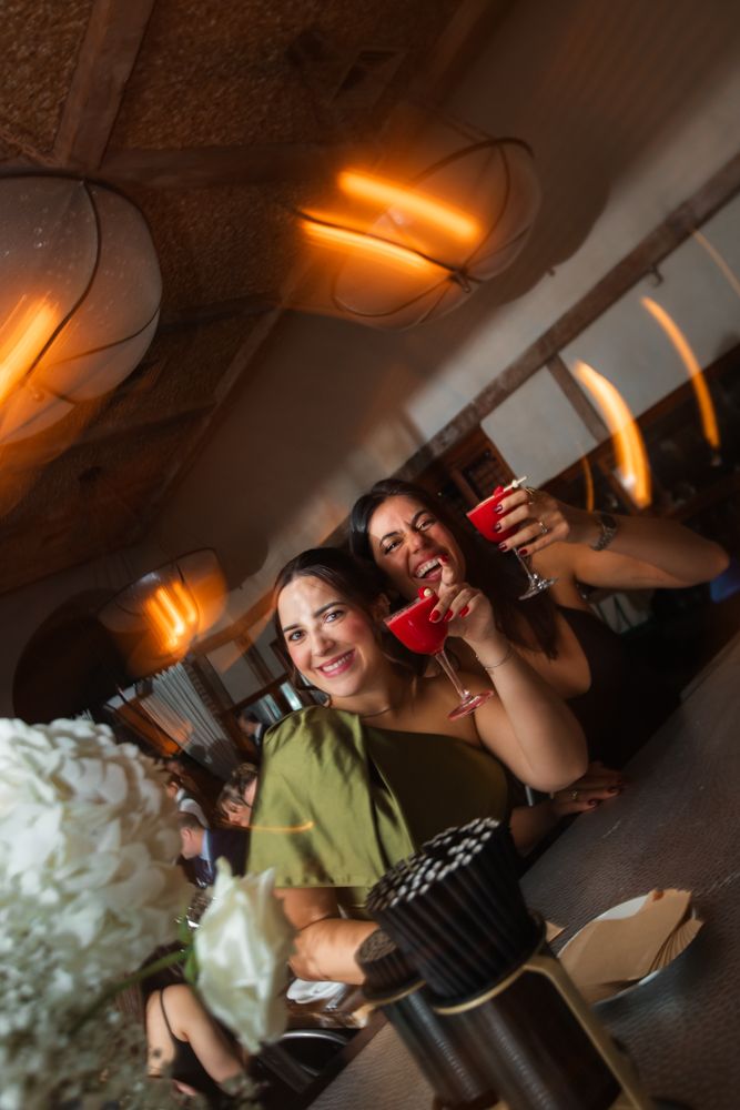 wedding guests posing for photo with drinks at the bar