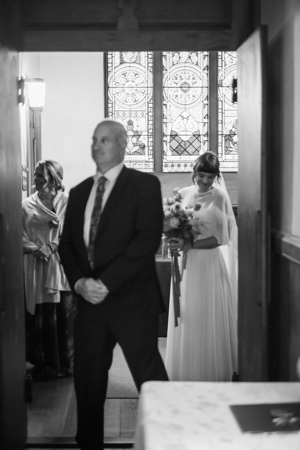 bride and father wait to walk down the isle in a church