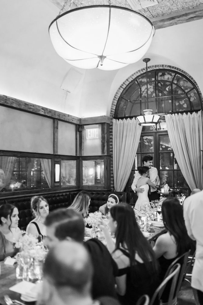 black and white photo of wedding reception with two people hugging