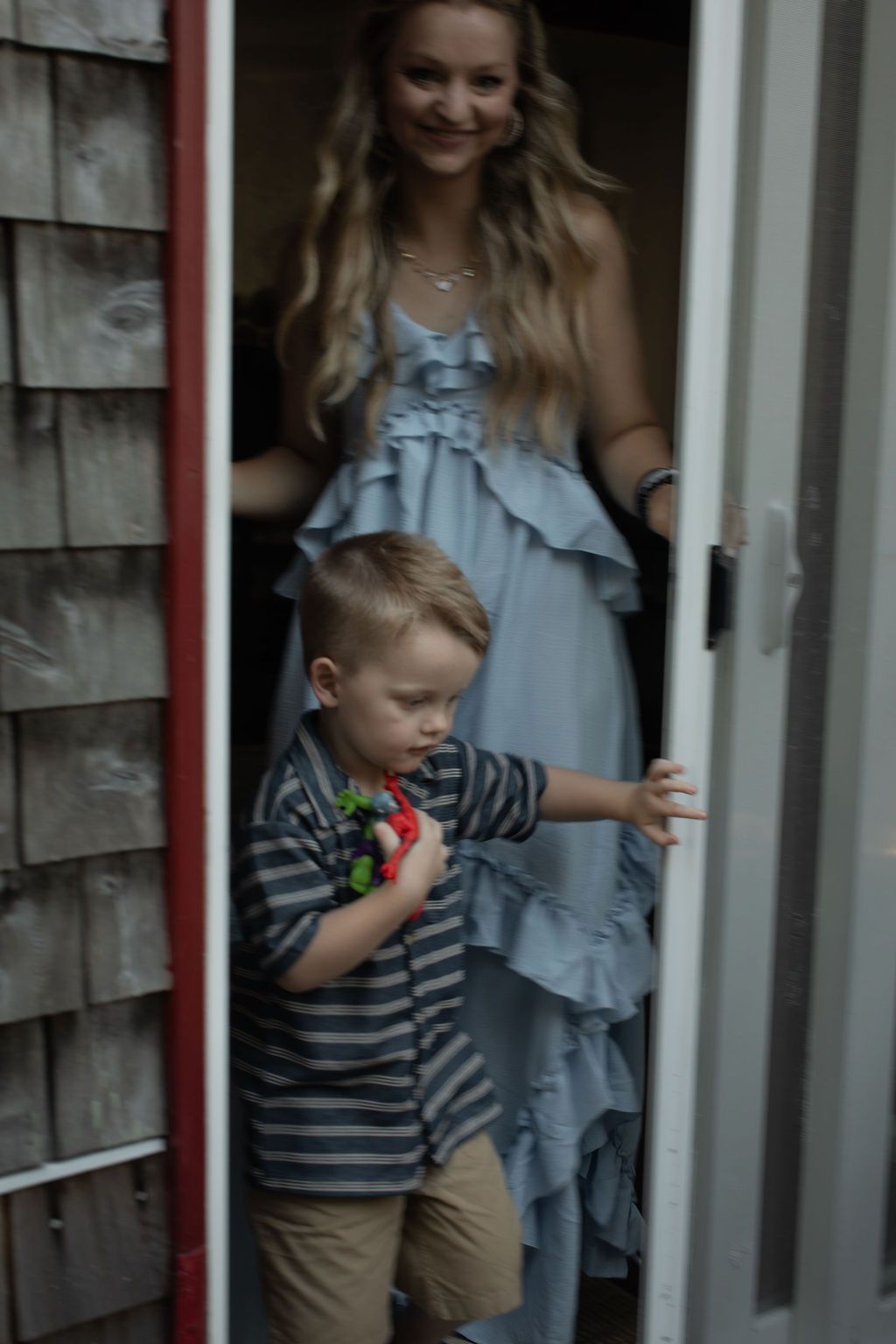 boy and mom joining the crowd through patio doors