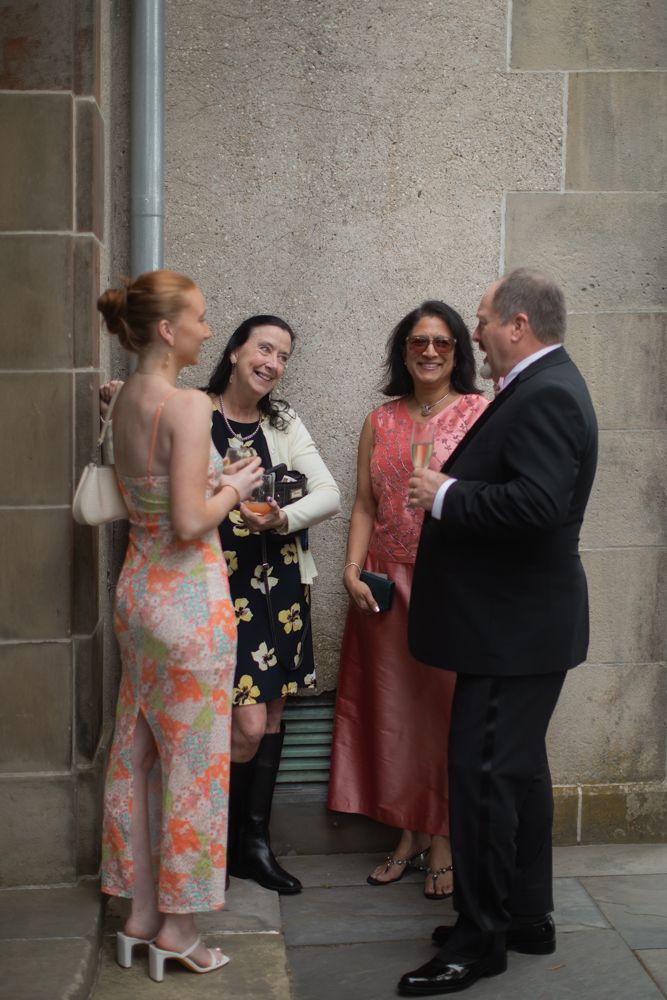 guests at wedding reception talking near stone doorway
