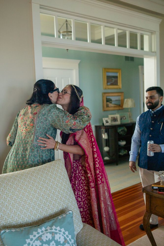bride and mother share a kiss before the first look