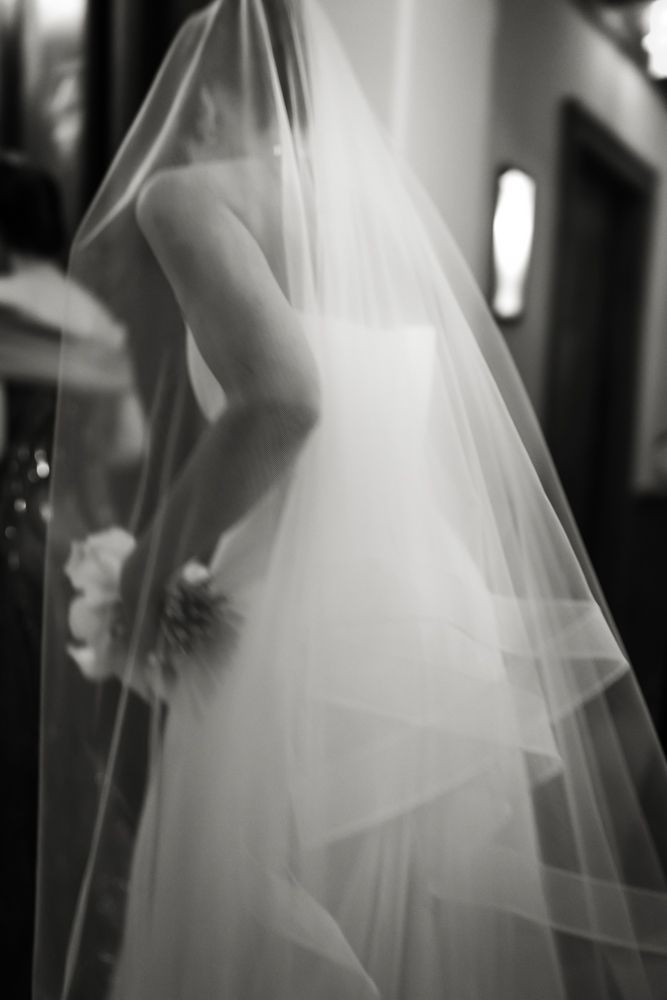 candid black and white photo of bride and veil