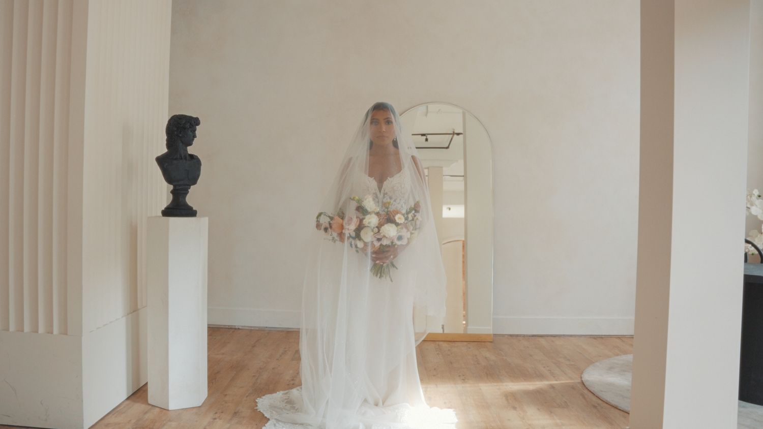 An elegant bridal preparation room with white columns and natural lighting.