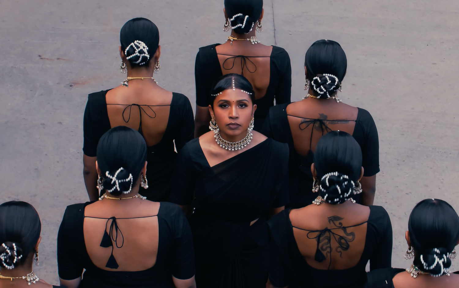 Row of girls in black sarees dancing