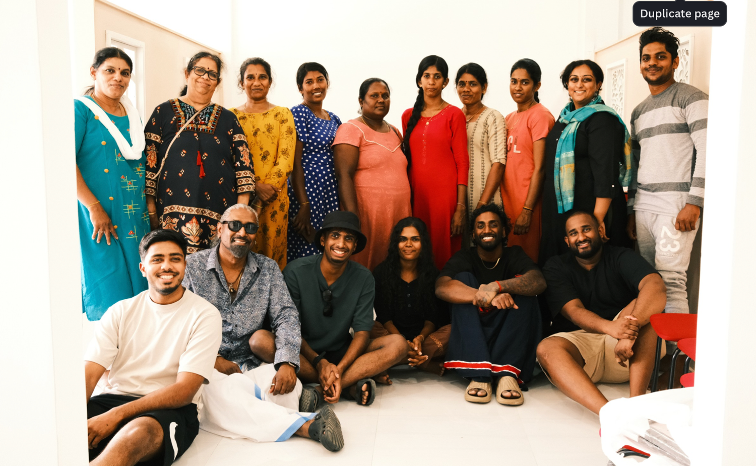 Group of people smiling and posing together in casual attire for a team photo.