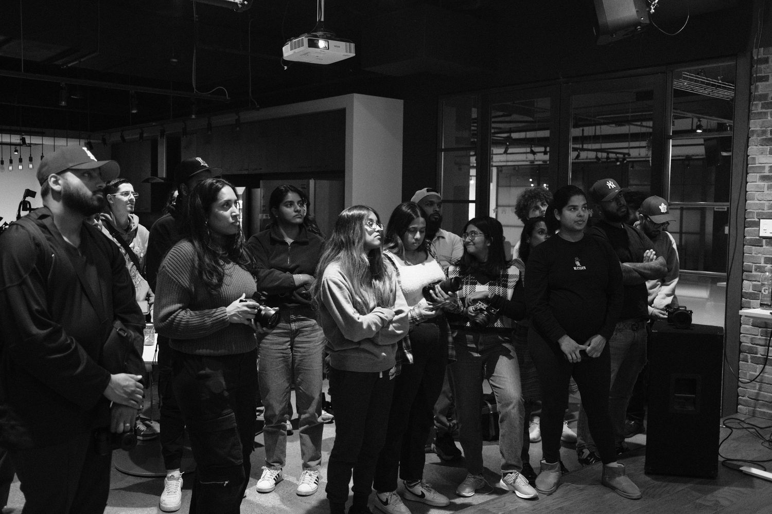 Dark office interior with people gathered in casual meeting setup.