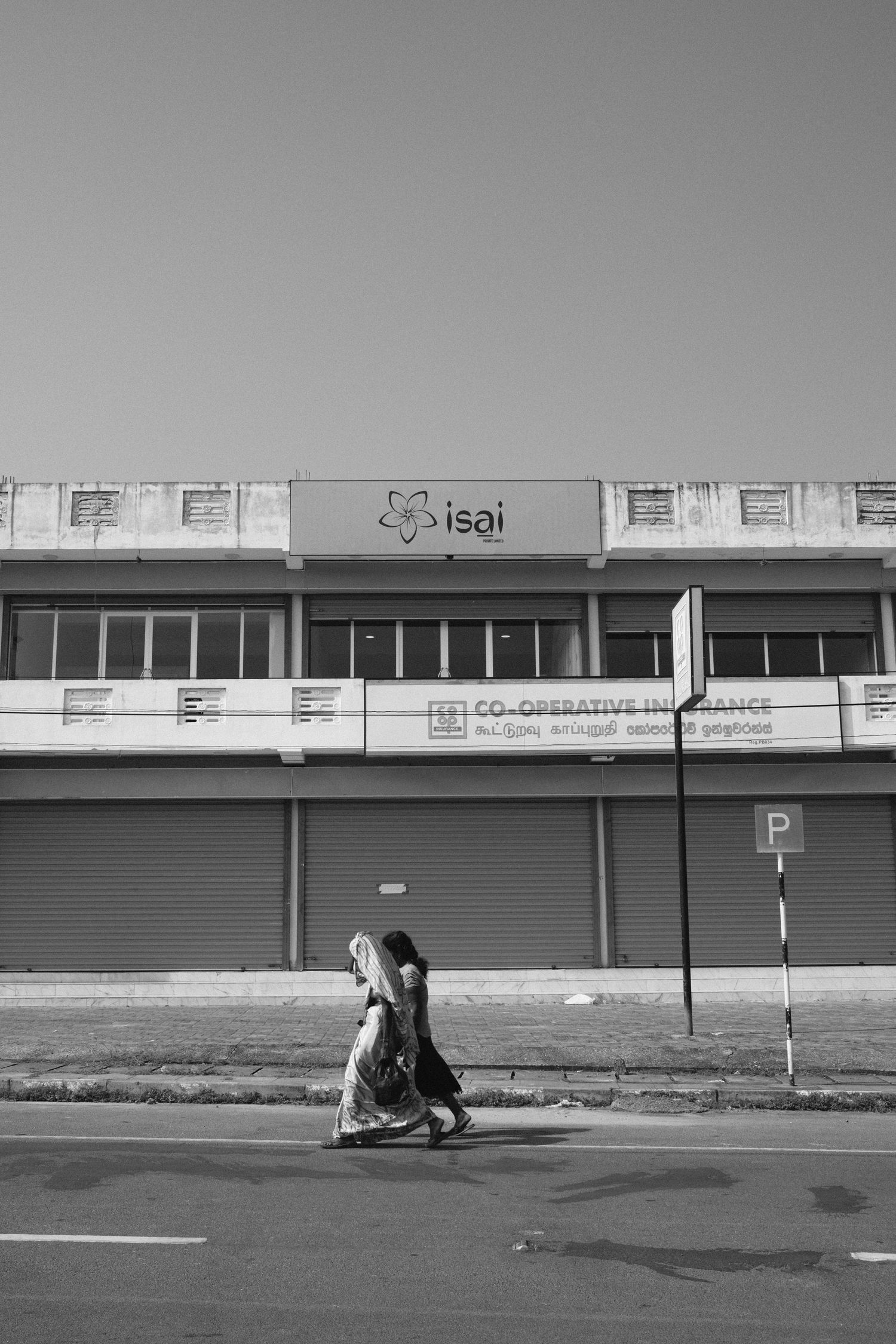 Black and white urban street scene with closed storefronts.