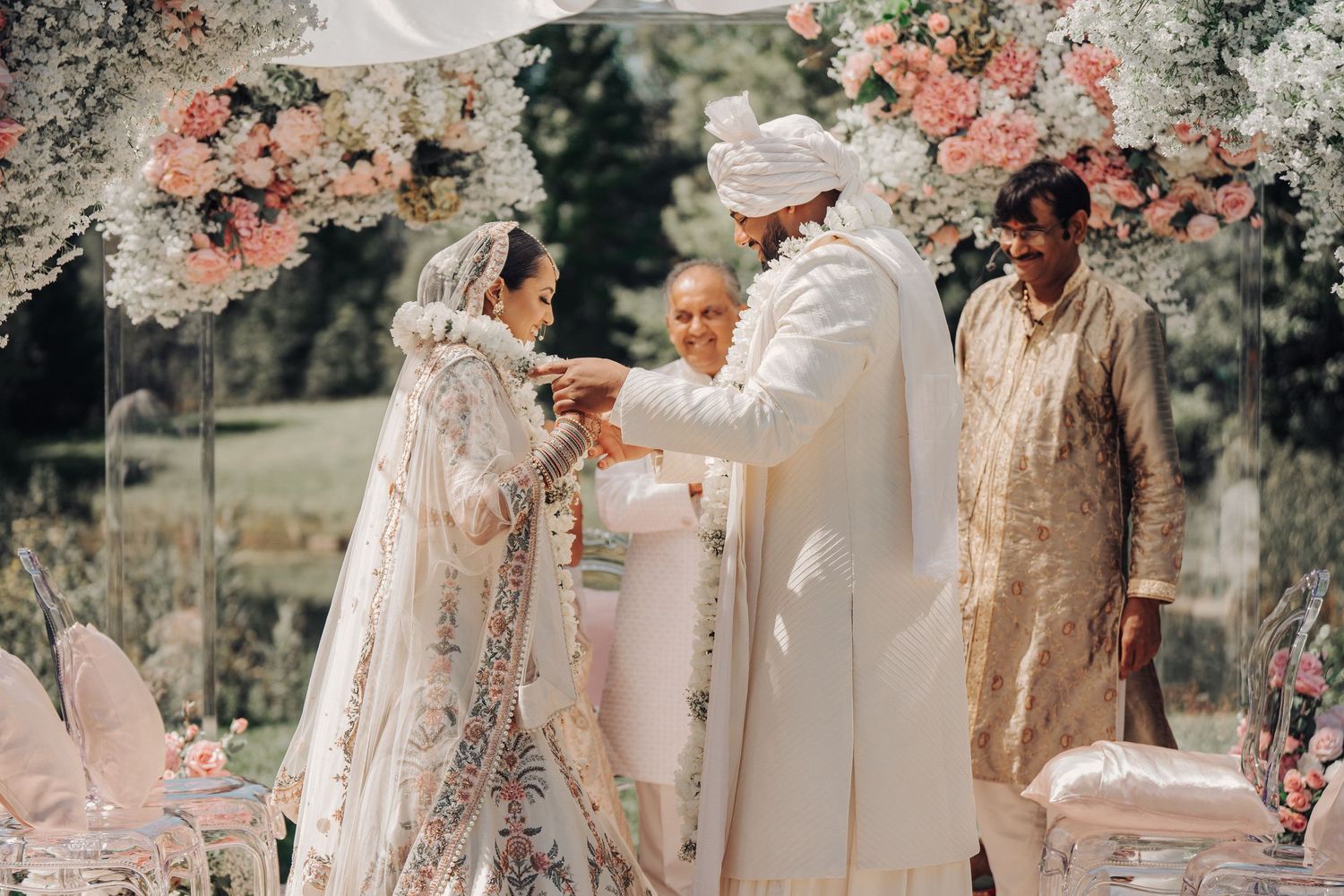 A traditional outdoor wedding ceremony setup with white decor and floral arrangements.