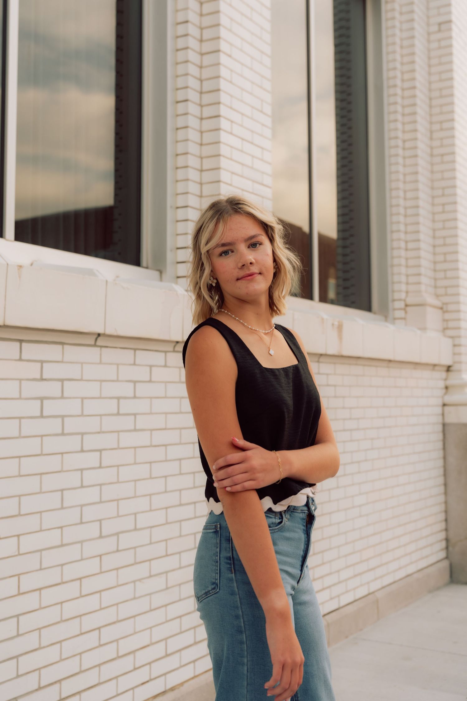 Candid fashion portraits showcasing casual summer style against white brick walls.