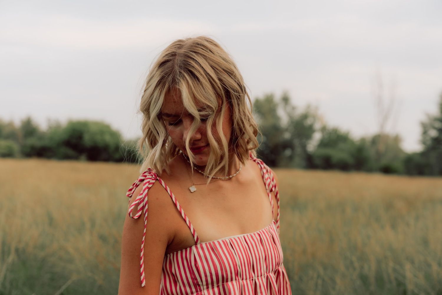 Close-up shot of red and white striped dress detail against natural outdoor setting.