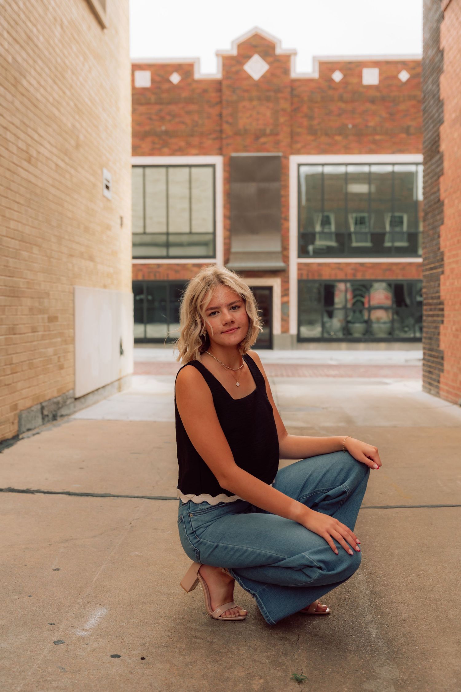 Casual fashion poses captured in an urban setting with mixed brick textures.