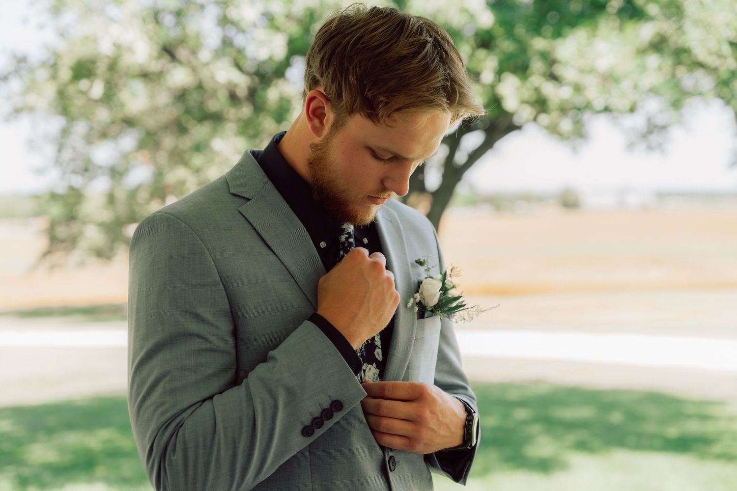 An emotional moment captured as someone in a grey suit wipes tears from their eyes.