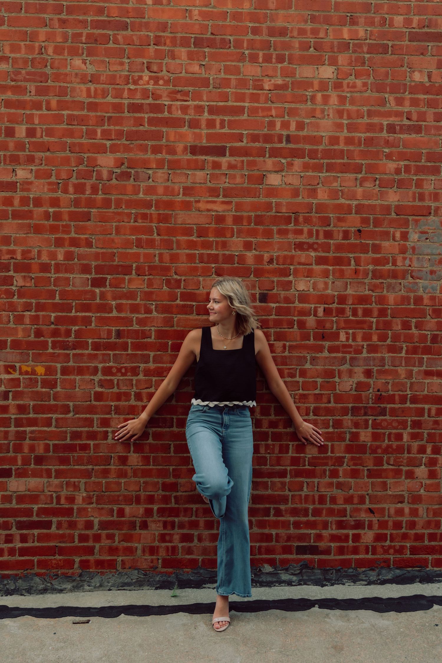 Fashion poses against red brick wall showcasing casual summer streetwear.