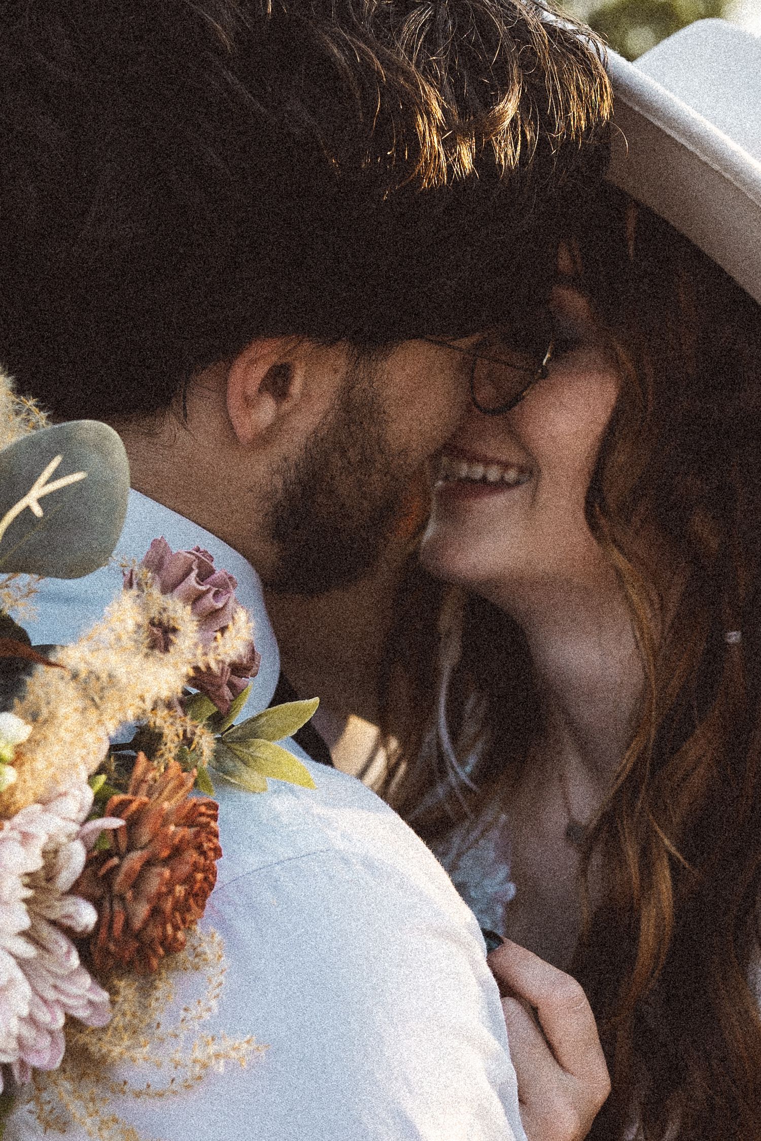 A close-up romantic moment with soft natural lighting and floral accents.