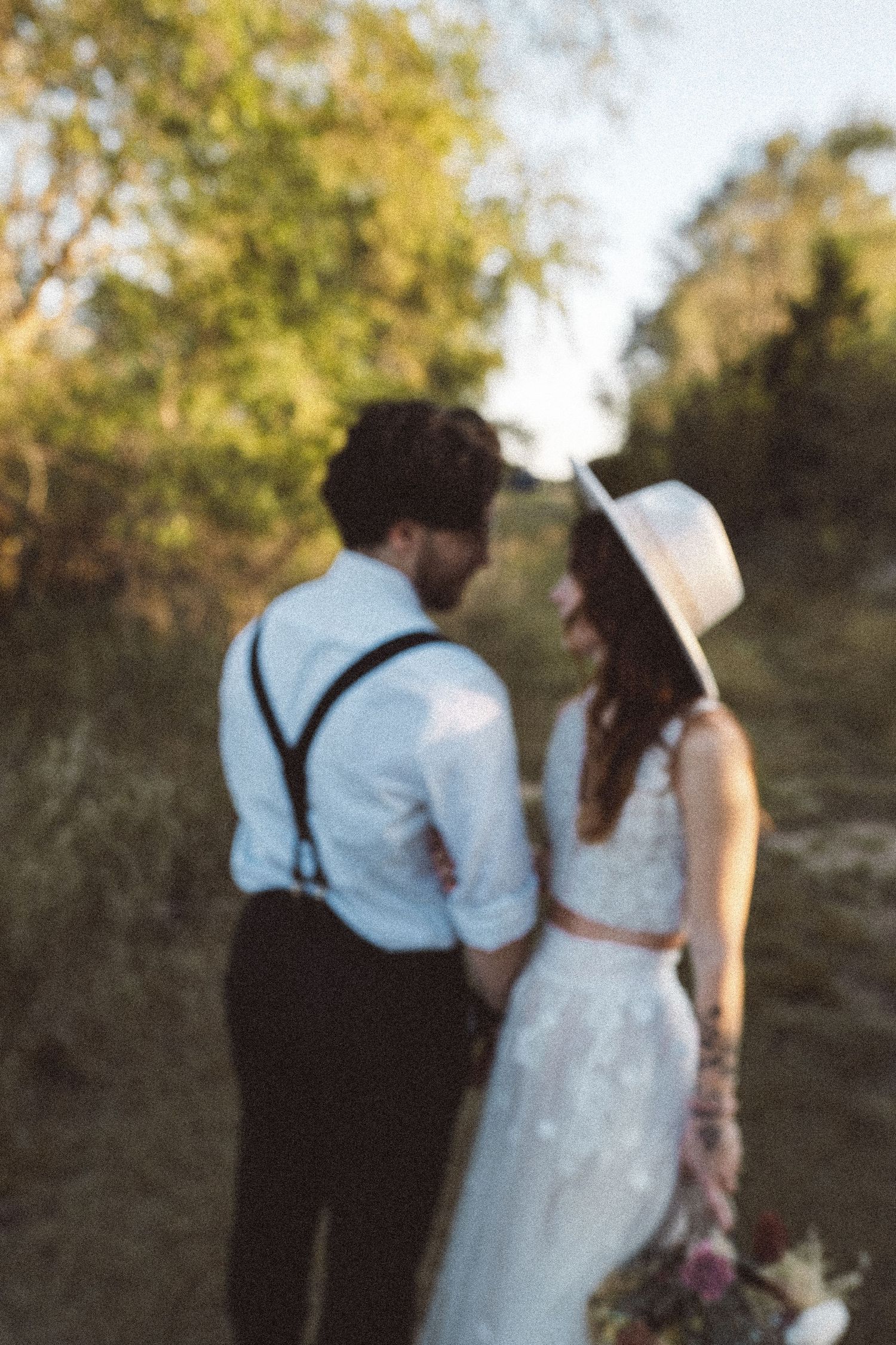 Wedding couple walking together on a scenic path surrounded by autumn foliage.