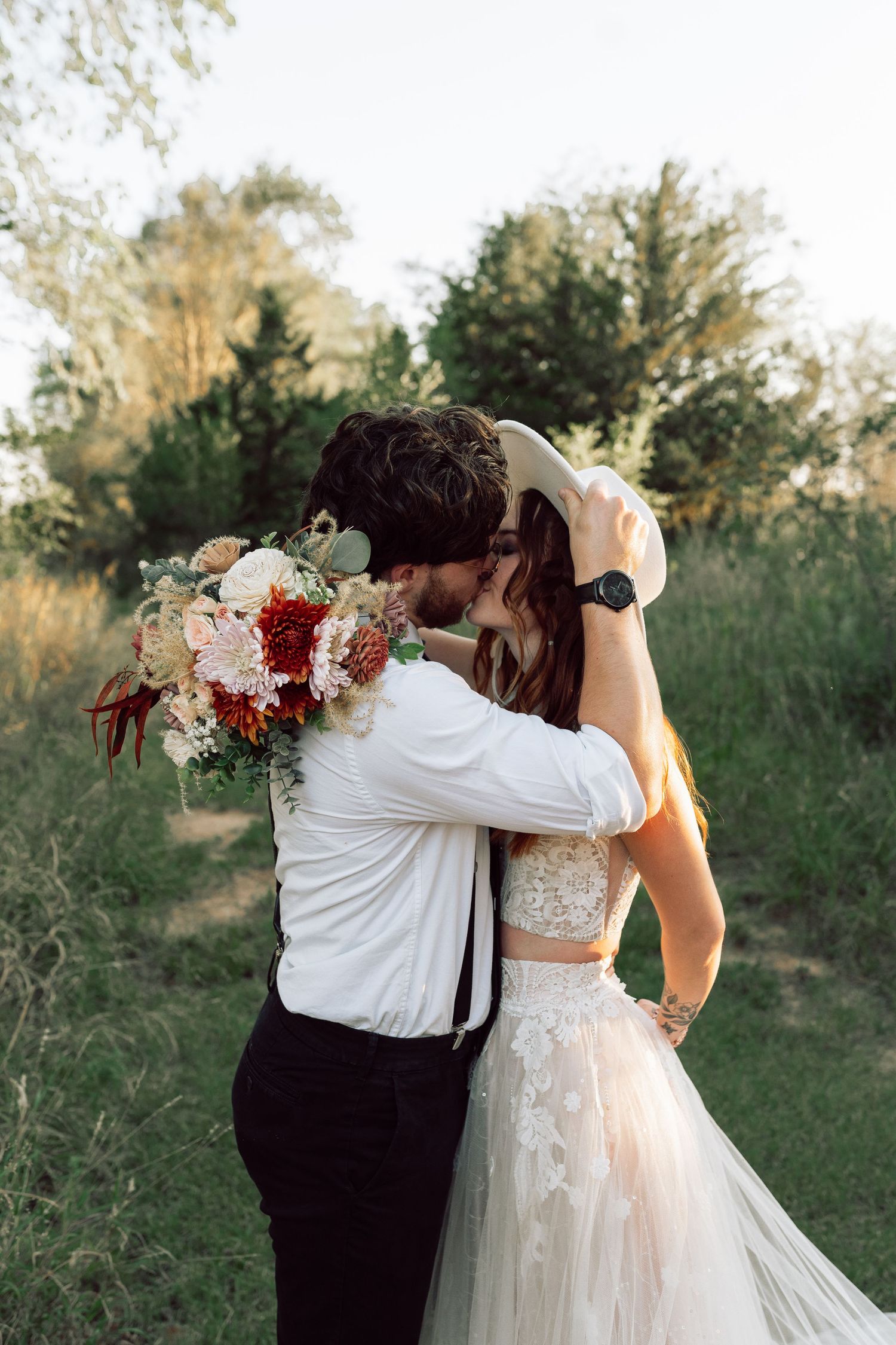 A romantic moment shared between newlyweds in a rustic outdoor setting.