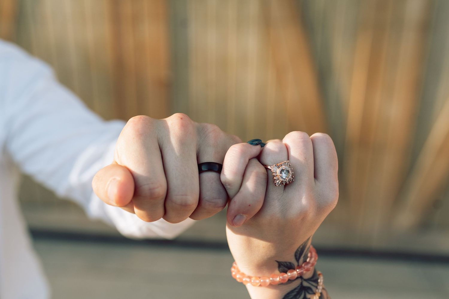 Close-up of hands showing engagement and wedding rings.
