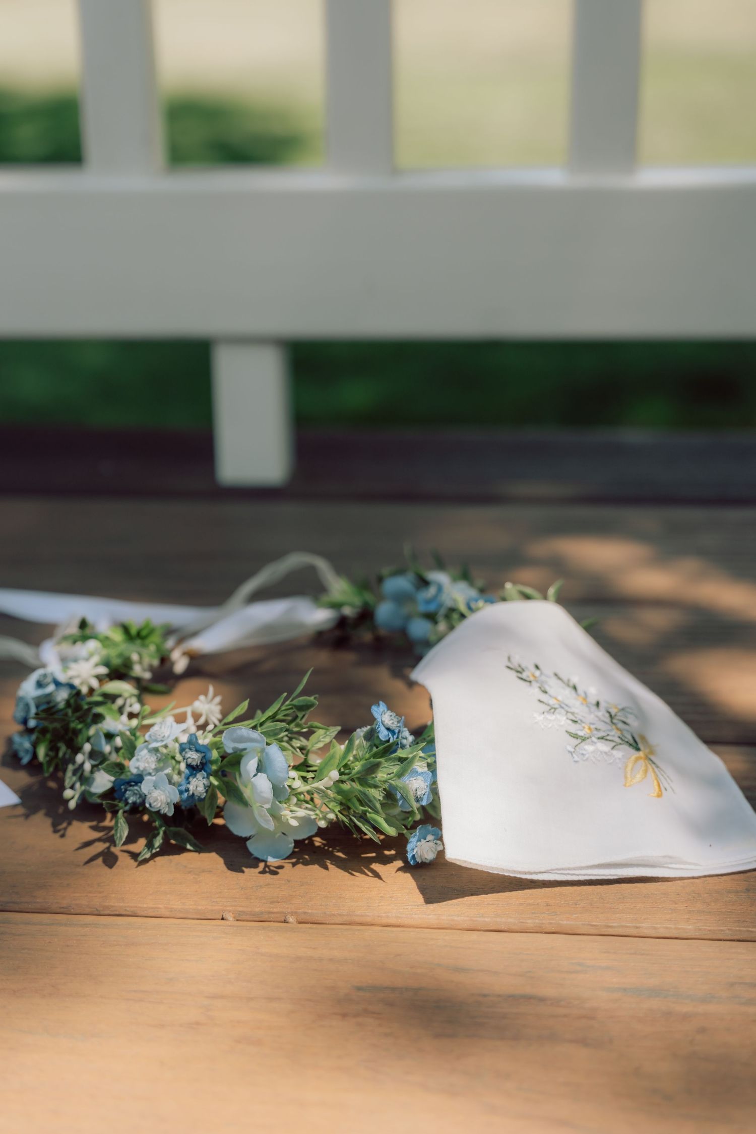 White face masks decorated with delicate flowers and greenery laid out on wooden surface.