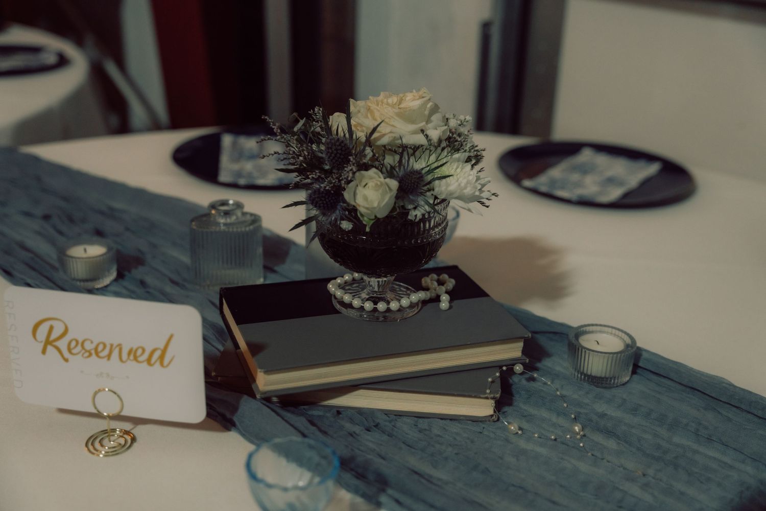 Vintage typewriter and wedding decor arranged on a rustic table with soft lighting.