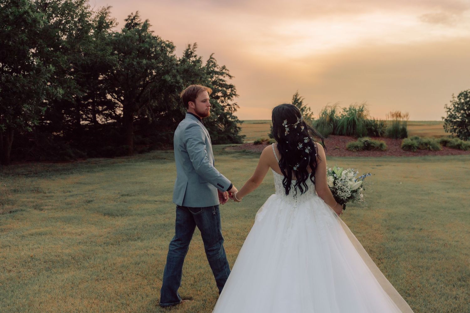 Sunset wedding photography session captures romantic moments in a rural field.