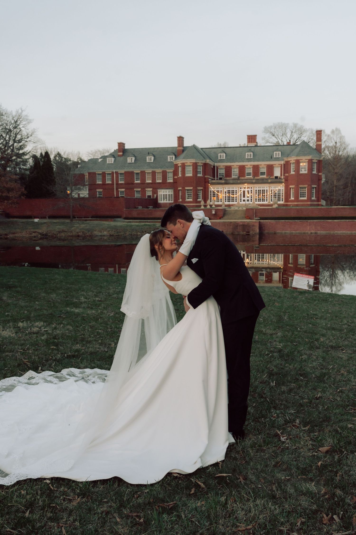 Winter wedding photos with flowing white gown against brick building backdrop.