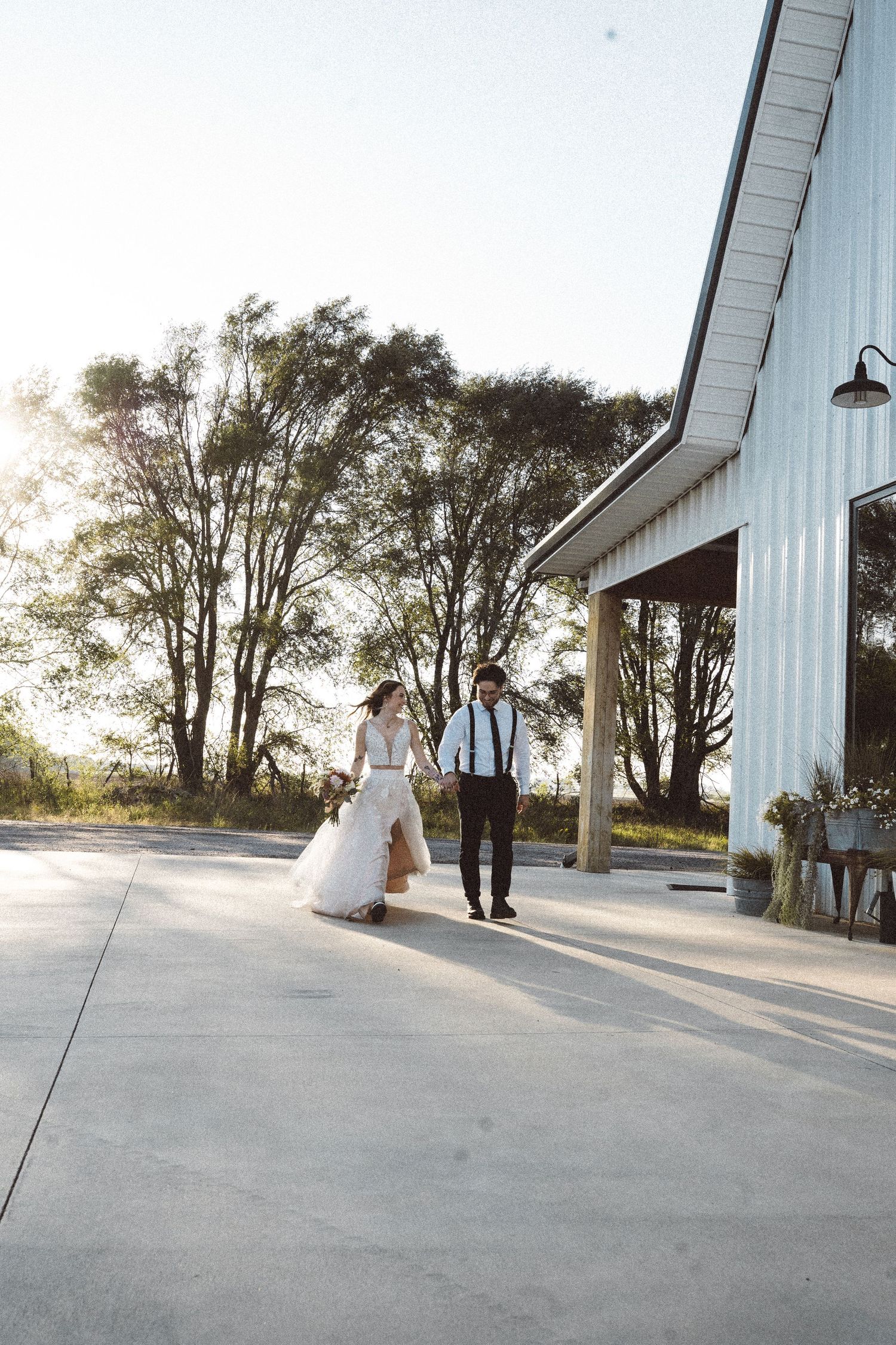 Elegant dance moves performed outside a rustic white barn venue.