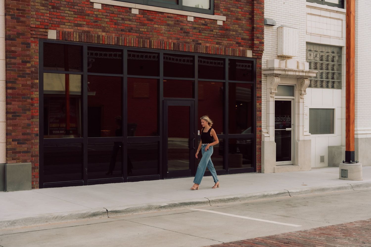 Long view of a brick building exterior with concrete walkway.