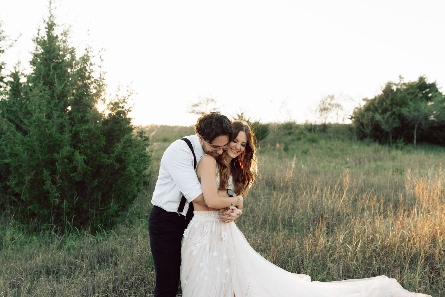 Wedding couple in romantic pose against scenic natural backdrop at golden hour.