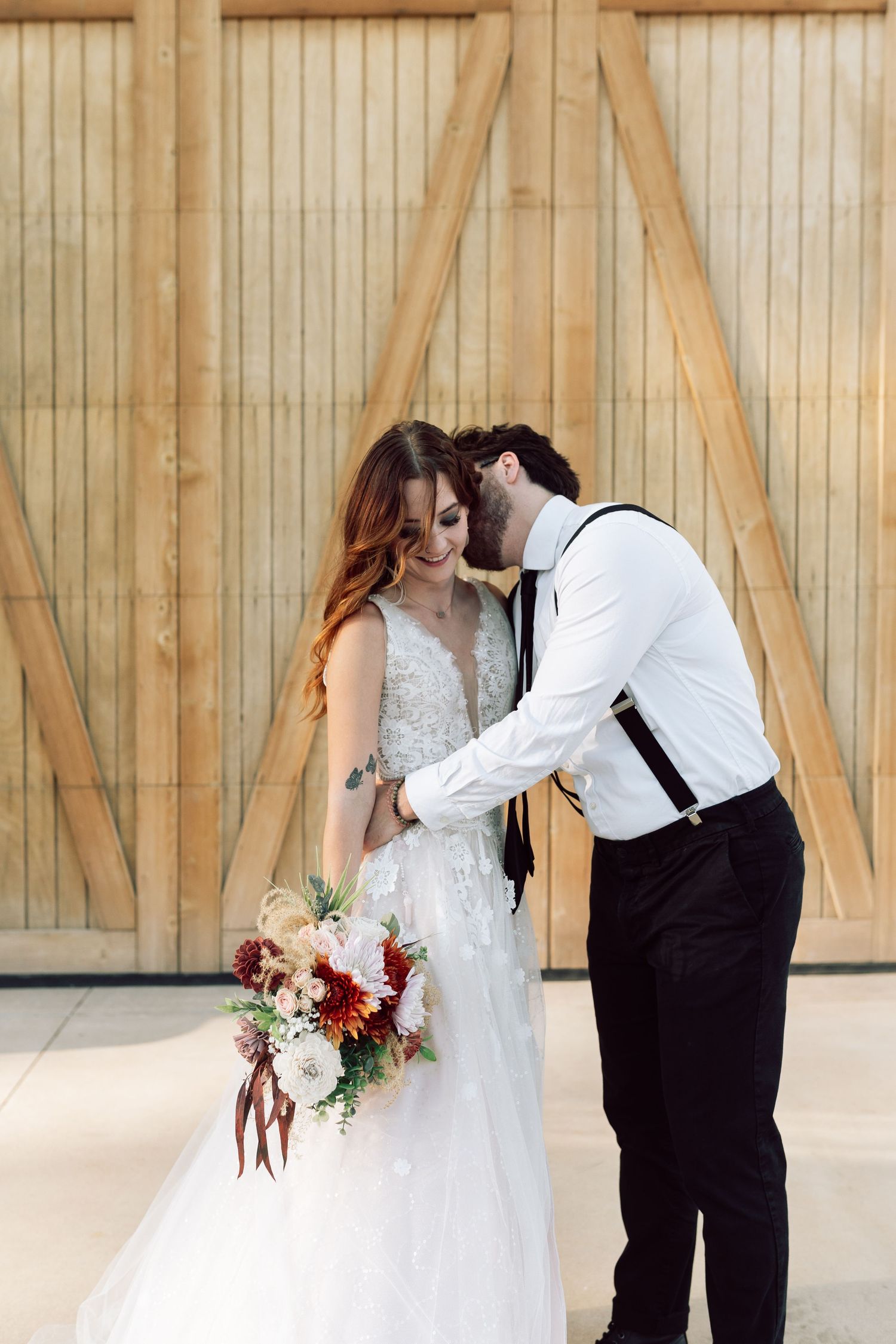 Wedding couple sharing intimate moments against rustic barn door backdrop.