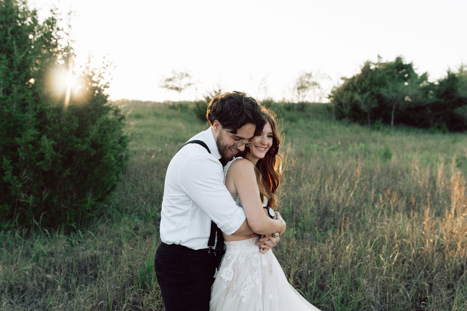 Romantic wedding portrait in natural setting with sunset glow and wildflowers.