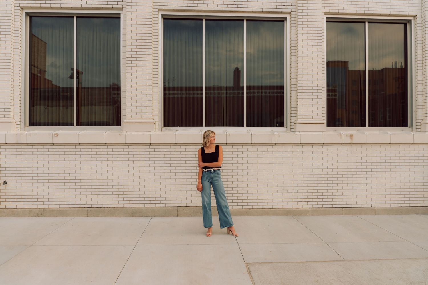 Artistic fashion poses photographed against minimalist architectural backdrop.