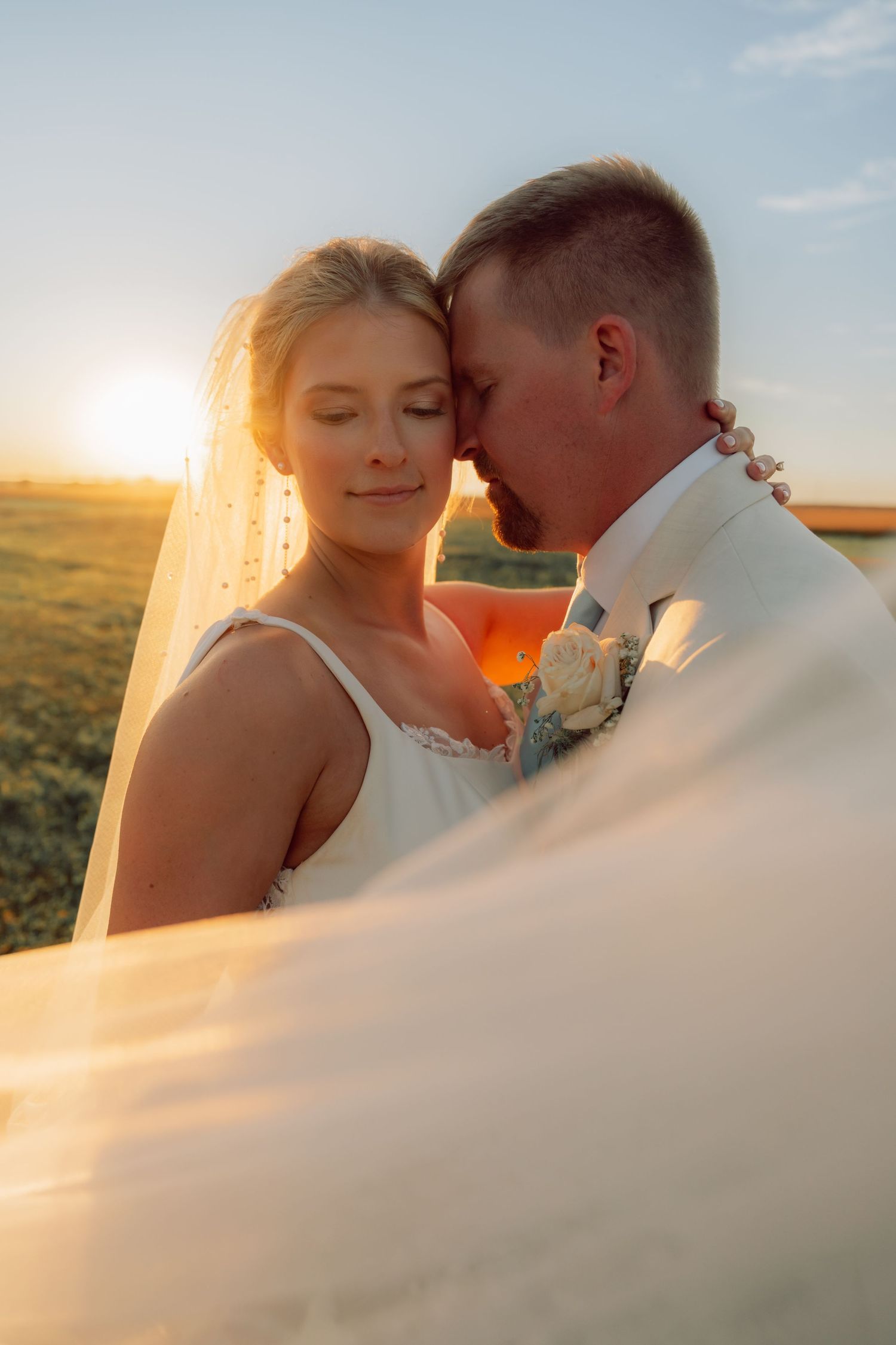 Romantic sunset portrait with flowing veil in golden light.