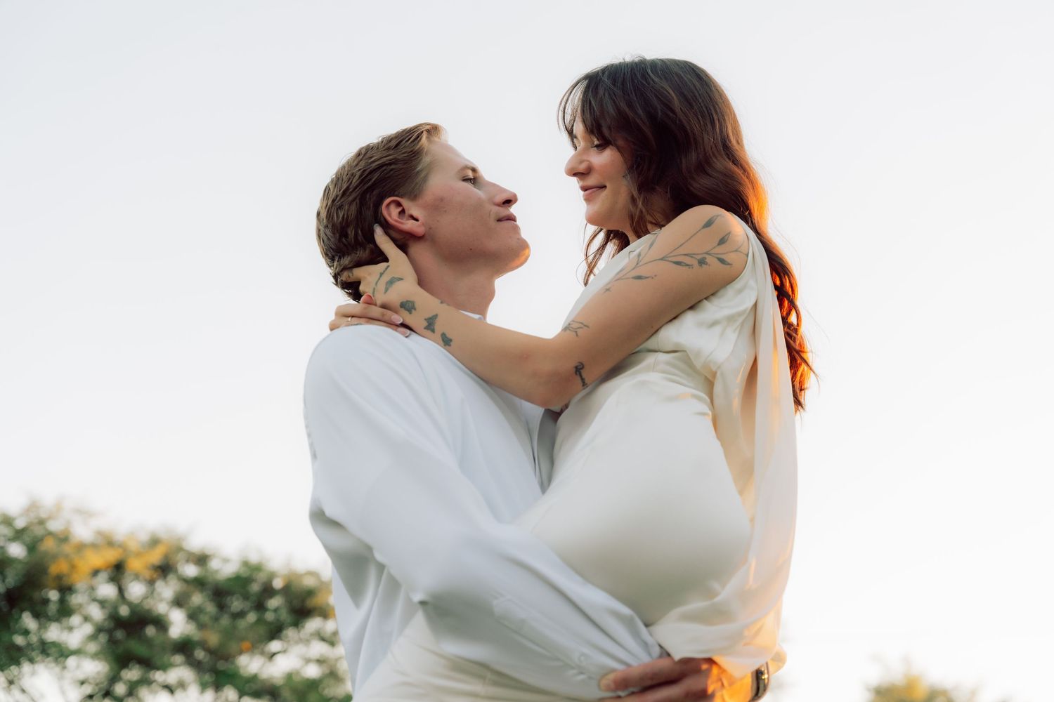 An intimate moment between two people captured in natural lighting outdoors.