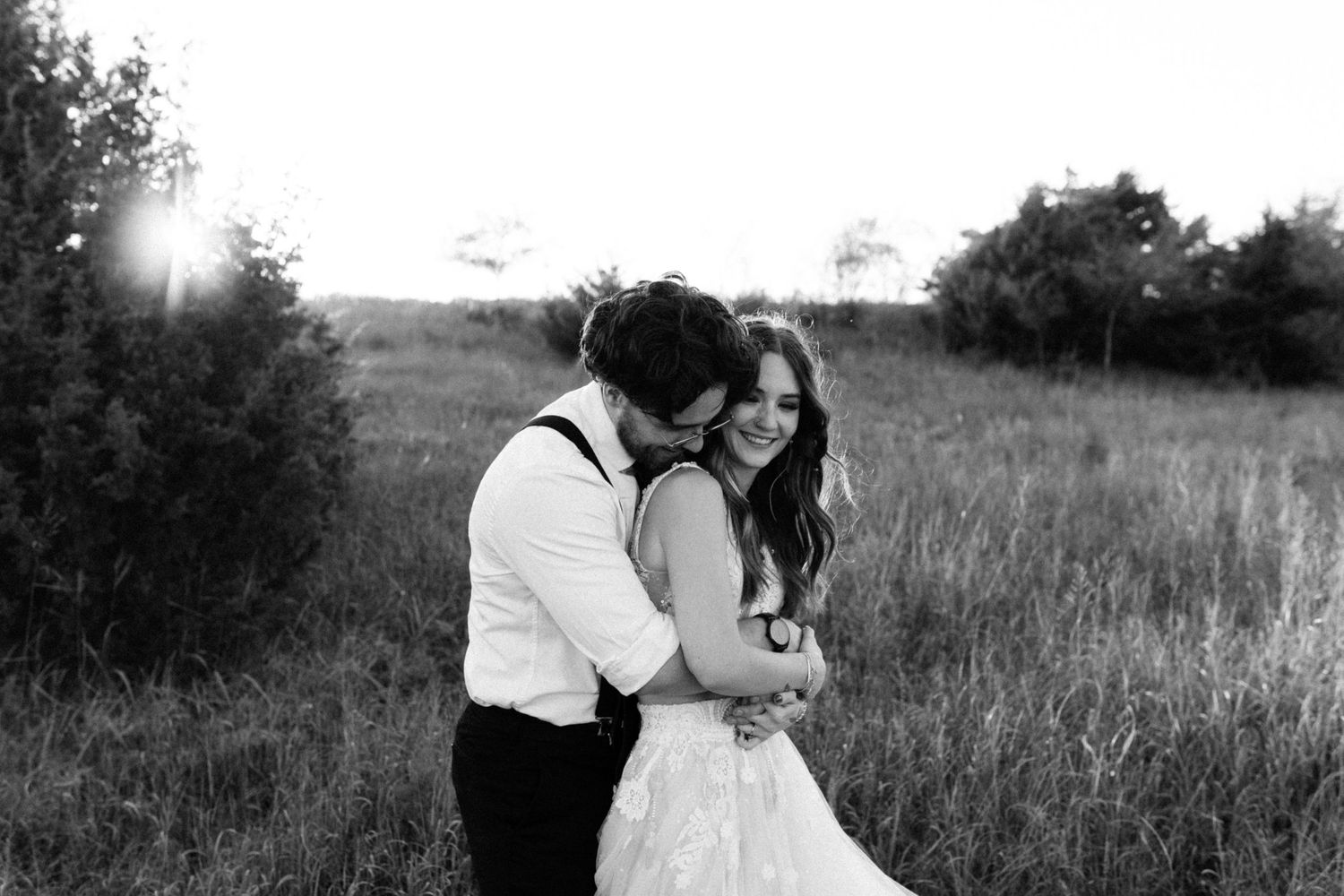 Black and white wedding photography capturing intimate moment in outdoor setting.