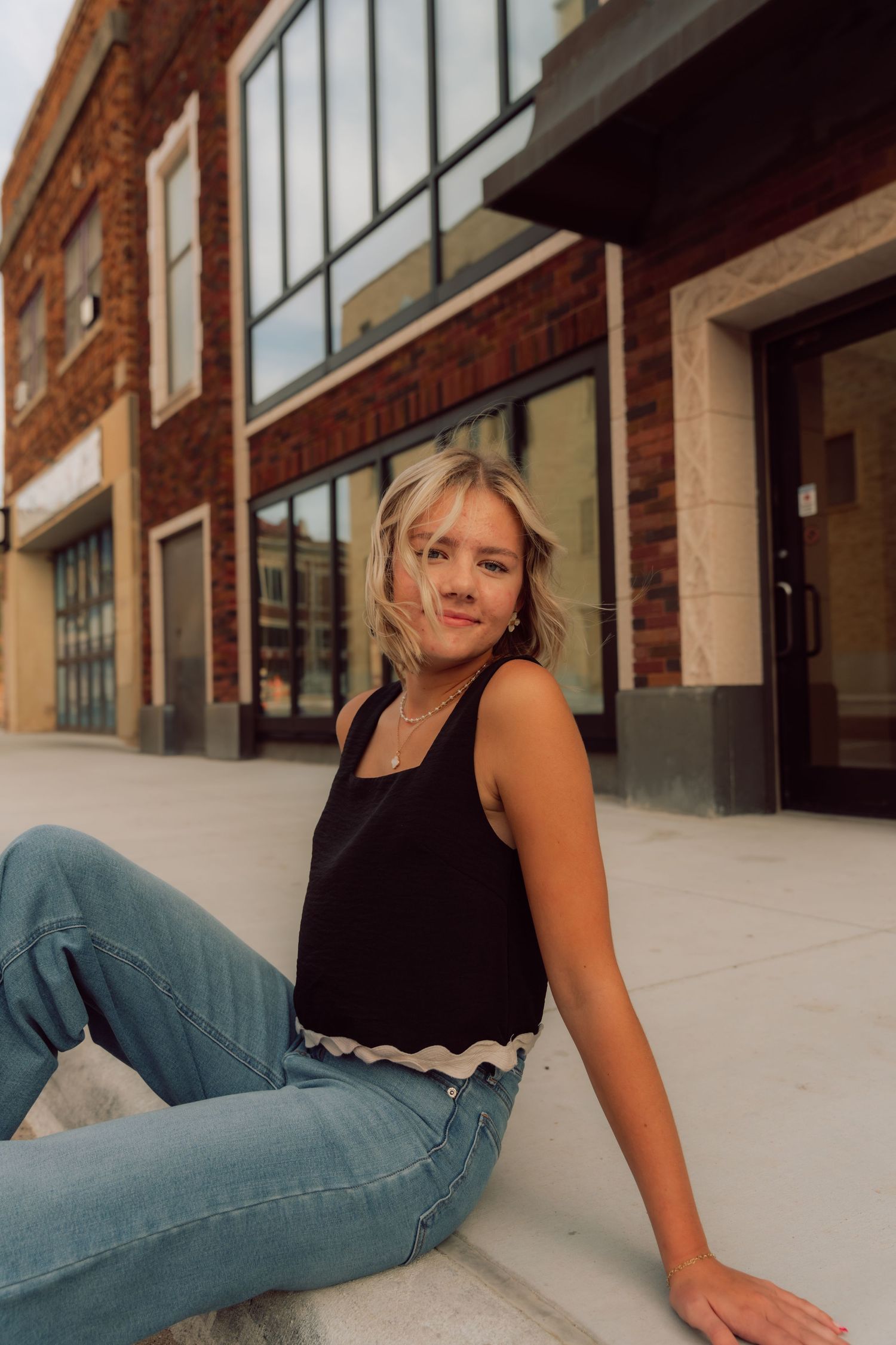 Casual portrait series against a brick building with industrial windows.