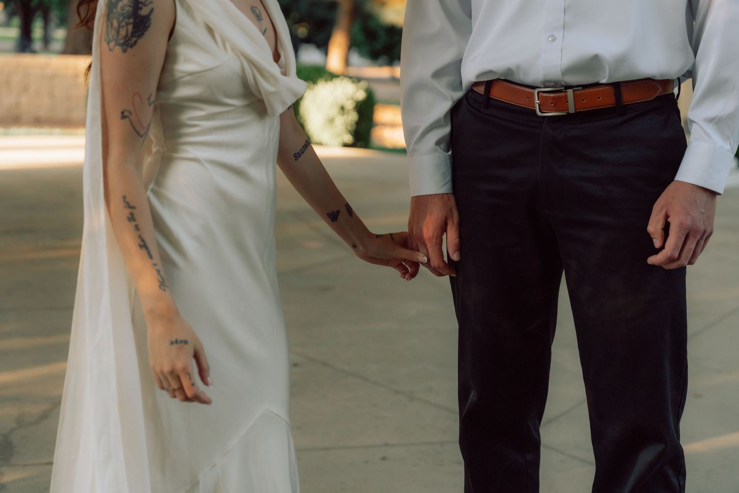 A couple in formal attire stands close together under a gazebo.